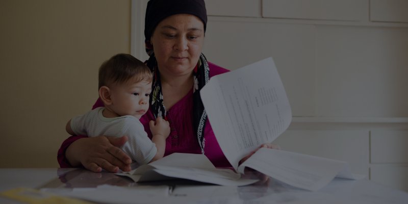Woman holding her young son looking at divorce papers