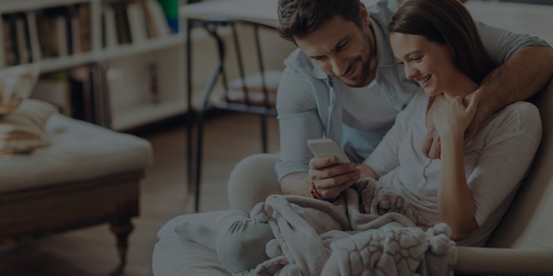 Couple on couch looking at phone together