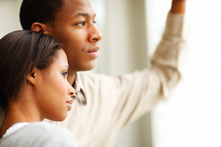 Man and woman looking out a window